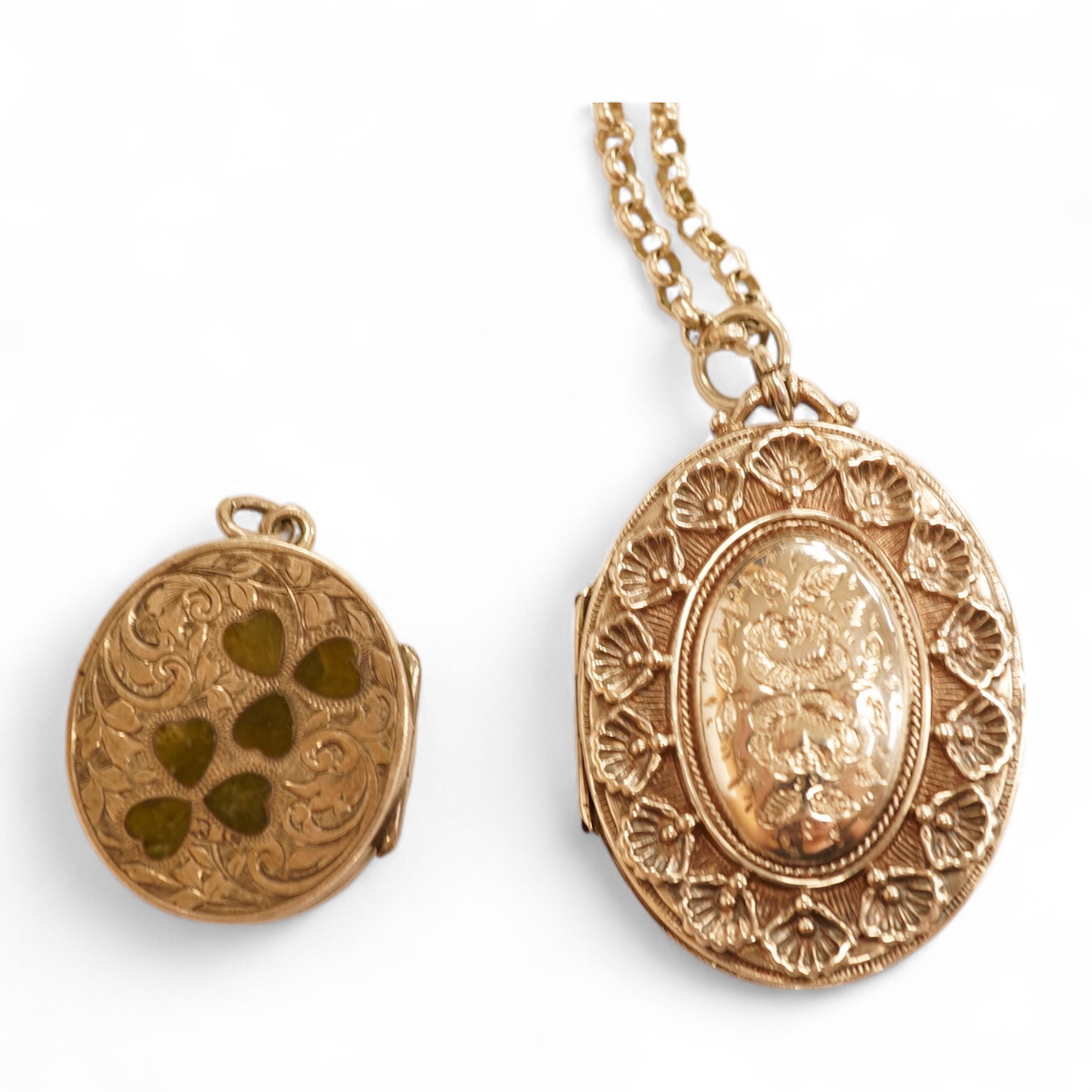 A late Victorian embossed and engraved oval silver locket, 42mm, on a later white meta belcher link chain, together with an Edwardian silver and hardstone inlaid pill box, now with pendant mount.
